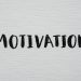 Inspirational word 'Motivation' in black on a white textured canvas background.